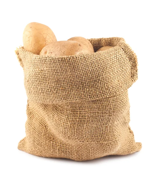 Patatas crudas en saco de arpillera — Foto de Stock