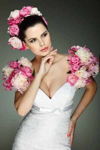 Uma morena sexual elegante está em um vestido de casamento, cores rosa decoradas — Fotografia de Stock