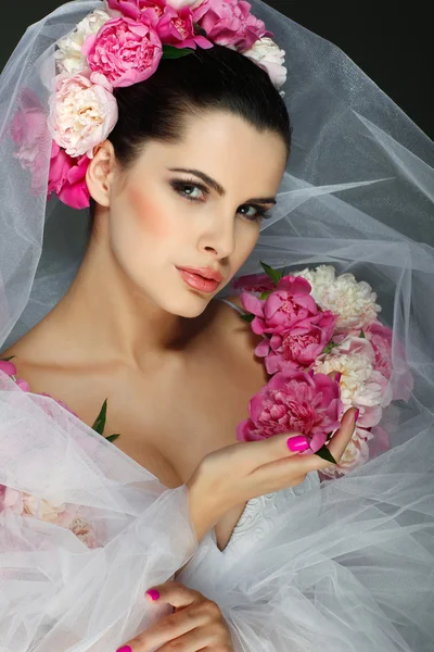 Een elegante seksuele brunette is in een trouwjurk, ingerichte roze kleuren — Stockfoto