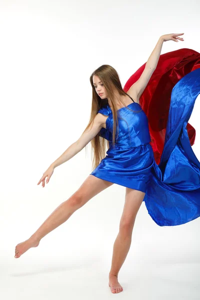 Gyönyörű lány, tánc a fújt a szövet a világos háttér — Stock Fotó