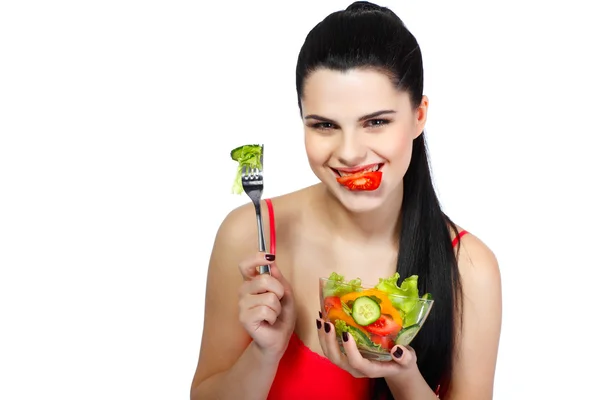 Retrato de una hermosa joven comiendo ensalada de verduras aislada sobre un fondo blanco —  Fotos de Stock