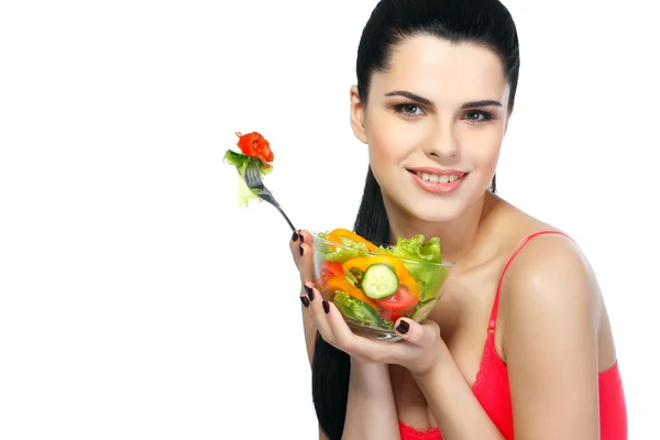 Retrato de uma jovem mulher bonita comendo salada de legumes isolada em um fundo branco — Fotografia de Stock