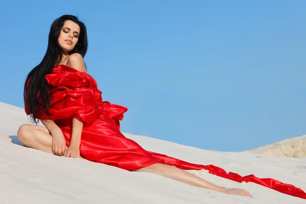 Sexuální dívka v červených šatech na pláži — Stock fotografie