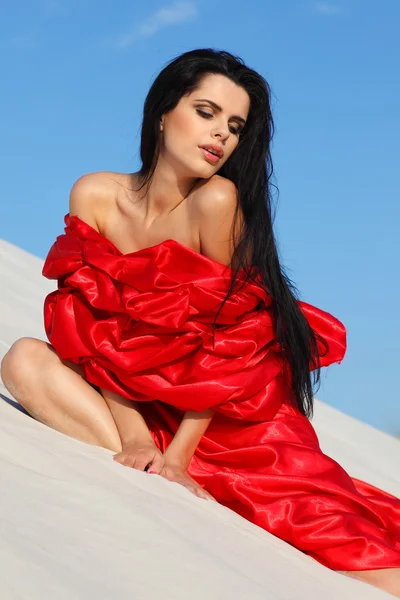 Bir sahilde kırmızı giysili genç cinsel kızı — Stok fotoğraf