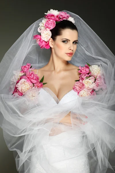Un'elegante bruna sessuale indossa un abito da sposa, decorato con colori rosa — Foto Stock
