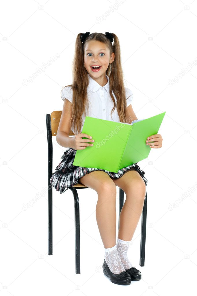 A little girl is in a school form which sits on a chair and reads