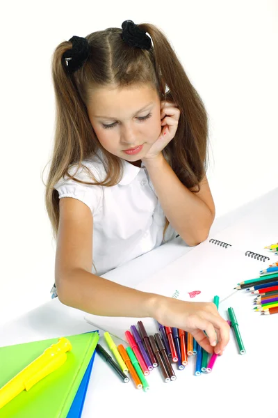 Una hermosa chica en una forma de escuela dibujando un marcador, aislado sobre un fondo blanco — Foto de Stock