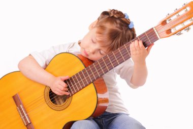 küçük kız eski bir gitar çalıyor.