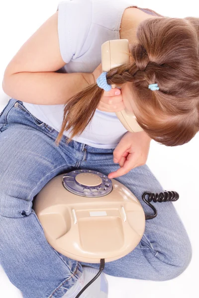 Liten flicka felringning i gamla telefon — Stockfoto