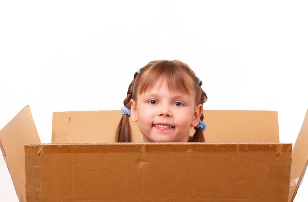 Little girl hiding in cardboard box — Stock Photo, Image