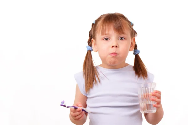 Menina com uma escova de dentes e um copo com água — Fotografia de Stock