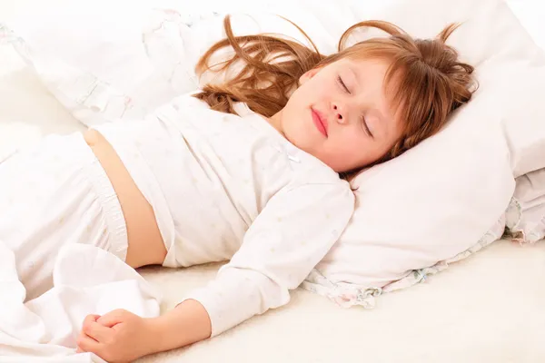 Vacker liten flicka sova i sängen — Stockfoto
