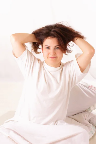 Gelukkig jonge vrouw zitten in bed — Stockfoto