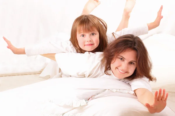 Две счастливые девушки лежат в постели — стоковое фото