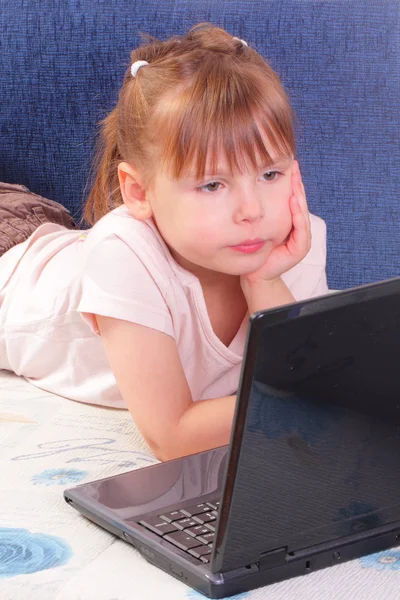 Vacker liten flicka med bärbar dator — Stockfoto