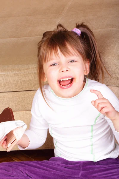 Menina feliz comendo chocolate — Fotografia de Stock