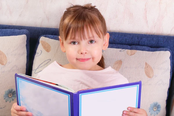 Красивая маленькая девочка сидит с книгой — стоковое фото