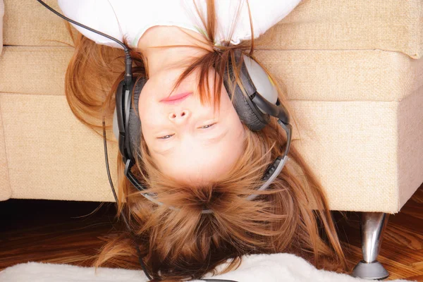 Pretty little girl upside down with headphones — Stock Photo, Image