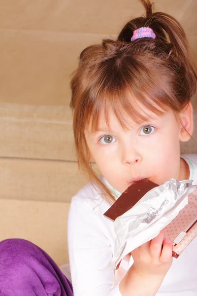 맛 있는 초콜릿을 먹는 아름 다운 어린 소녀 로열티 프리 스톡 이미지