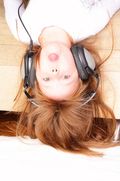 Engraçado menina de cabeça para baixo com fones de ouvido Fotos De Bancos De Imagens