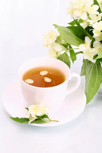 Cup of jasmine tea and flowers — Stock Photo, Image