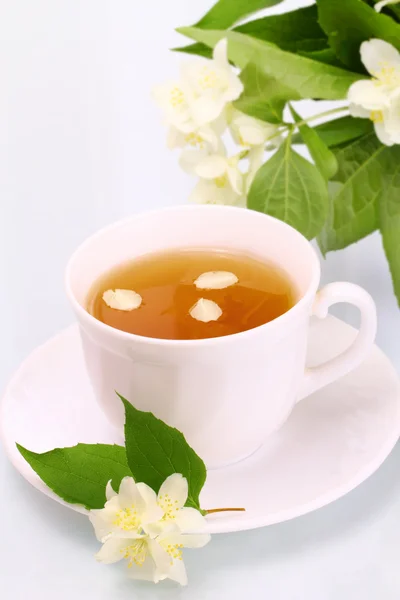 Tasty jasmine tea and beautiful flowers — Stock Photo, Image
