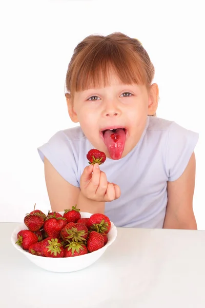 Engraçado menina comendo morangos saborosos — Fotografia de Stock