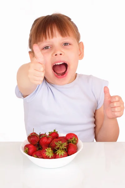 Happy little girl with a white soup plate with strawberries — Stock Photo, Image