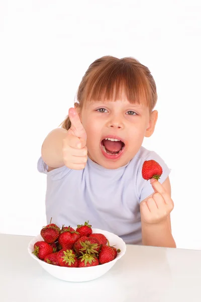 Happy little girl with a white soup plate with tasty strawberries — Stock Photo, Image