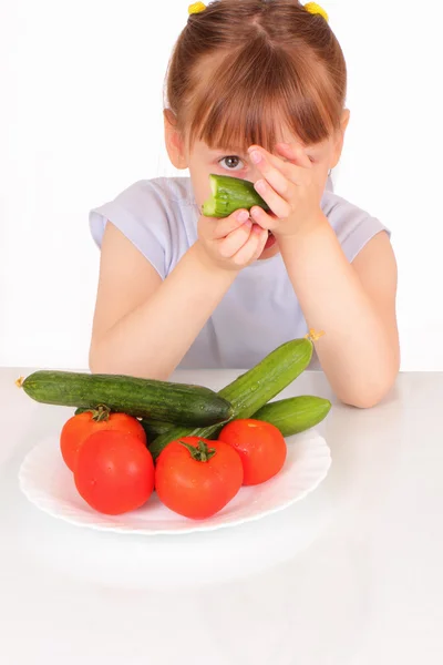 Bella bambina con un piatto bianco con cetrioli e pomodori — Foto Stock