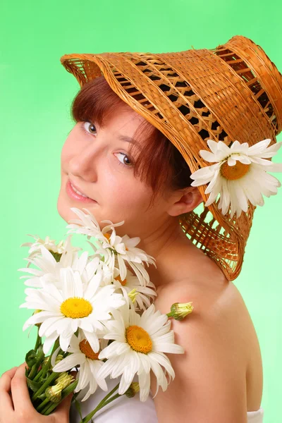 Mooie meisje in de hoed met kamille bloemen — Stockfoto