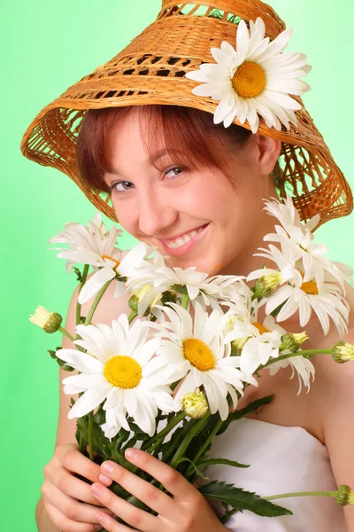 Grappig jonge meisje in de hoed met kamille bloemen — Stockfoto