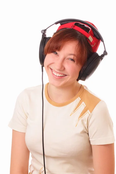 Sonriente chica joven escuchando música en los auriculares — Foto de Stock