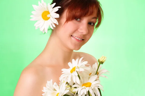 Smiling young girl with chamomile flowers — Stock Photo, Image