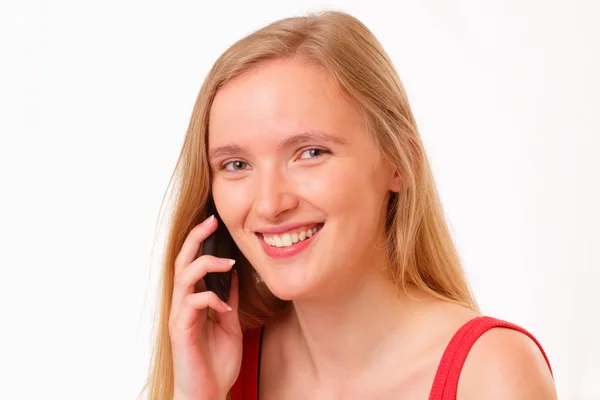 Улыбающаяся молодая девушка разговаривает по мобильному телефону — стоковое фото