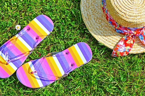 Kleurrijke slippers en een stro hoed — Stockfoto