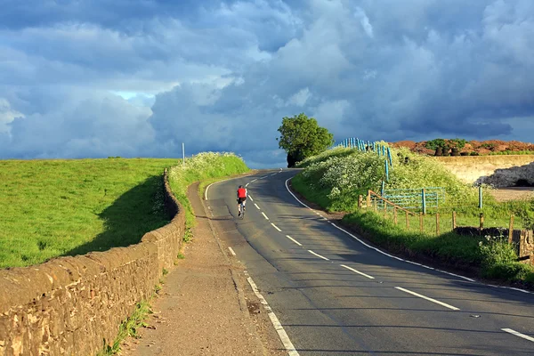 Belle route écossaise avec un cycliste solitaire dans la campagne — Photo