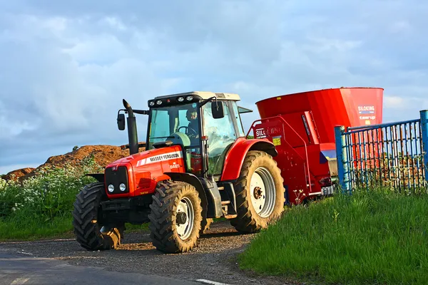 En röd lantbrukstraktor under våren jordbruksarbete — Stockfoto