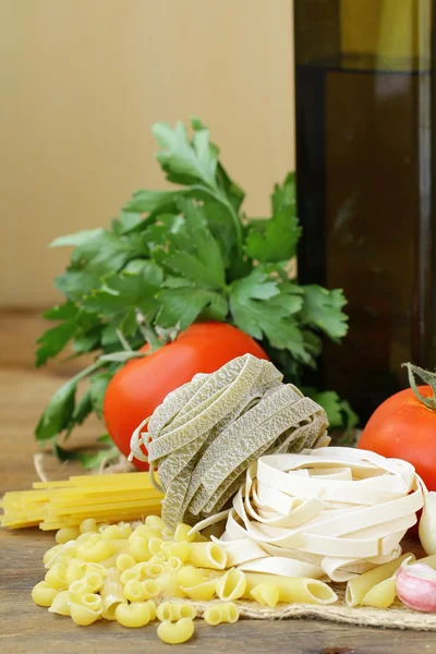 Different types of Italian pasta with tomatoes, spices and oil — Stock Photo, Image