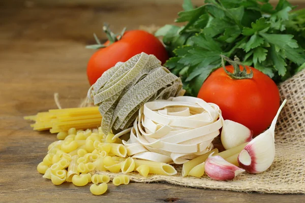 Différents types de pâtes italiennes aux tomates, aux épices et à l'huile — Photo