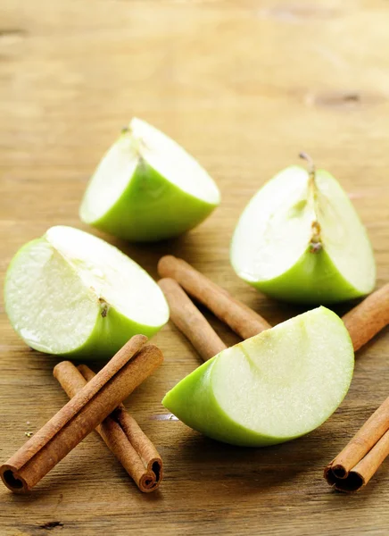 Zielone jabłka i cynamonu na tle drewniane — Zdjęcie stockowe