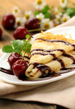 Sweet pancake with chocolate sauce and cherries