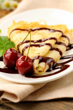 Sweet pancake with chocolate sauce and cherries