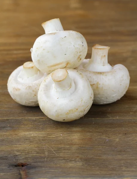 Cogumelos champignon em uma mesa de madeira — Fotografia de Stock