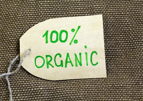 Органическая этикетка на естественном фоне мешковины — стоковое фото
