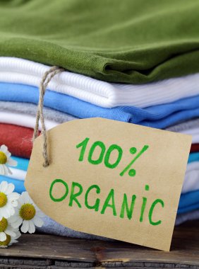 Stack of colorful clothing with organic label clipart