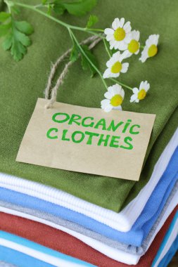 Stack of colorful clothing with organic label clipart