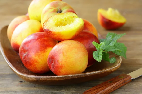 stock image Red ripe peaches on wooden table