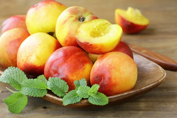 Red ripe peaches on wooden table — Stock Photo, Image