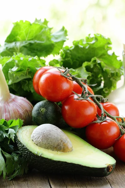 Avocado, Tomaten, Salat und Öl auf einem Holztisch — Stockfoto